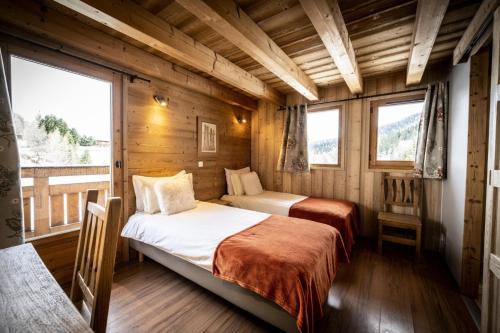 - 2 lits dans une chambre dotée de murs en bois et de fenêtres dans l'établissement Les Chalets Du Cocoon - 6 Pièces pour 11 Personnes 611, à Aime La Plagne