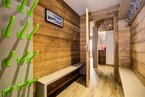 Cette chambre est dotée d'un mur en bois avec un banc. dans l'établissement Chalet De La Mine - CHALET MINE 2 MAE-1621, à Aime La Plagne
