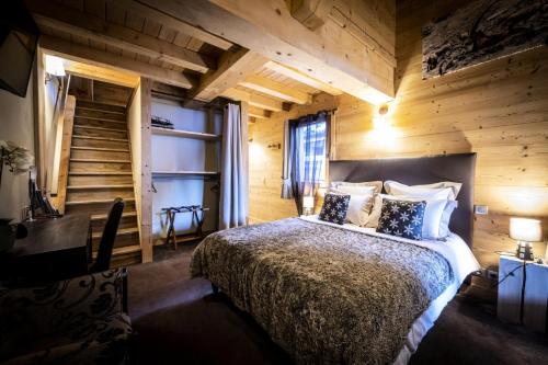 une chambre avec un lit dans une pièce en bois dans l'établissement Les Chalets Du Cocoon - CHALET PIERRA MENTA 1 MAE-1641, à Aime La Plagne
