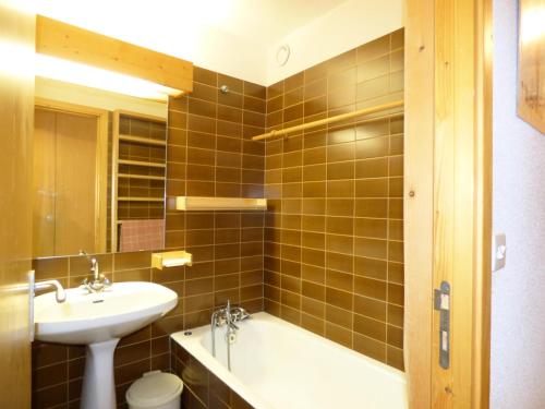 une salle de bain avec un lavabo et une baignoire dans l'établissement Résidence Les Genelles - Appartement 3 Pièces situé à Méribel Altiport au pied des pistes de ski et proche du golf MAE-6691, à Les Allues