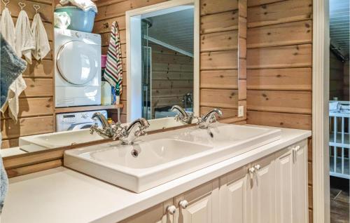 a bathroom with a sink and a refrigerator at Lovely Home In Rysstad in Rysstad