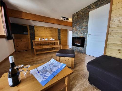 une chambre avec une bouteille de vin et une table avec une carte dans l'établissement Les Chalets De Bois MÉan - A - Duplex 6 couchages joliment décoré MAE-3731, aux Orres
