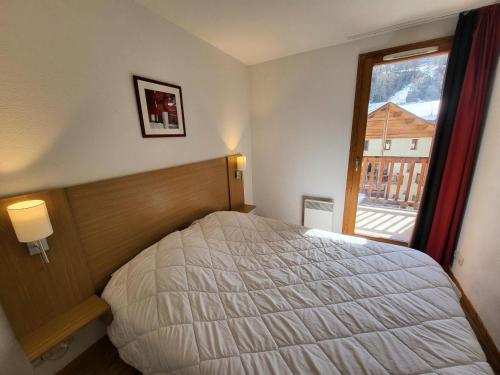 une chambre avec un grand lit et une fenêtre dans l'établissement Les Chalets De Bois MÉan - A - Duplex 6 couchages joliment décoré MAE-3731, aux Orres