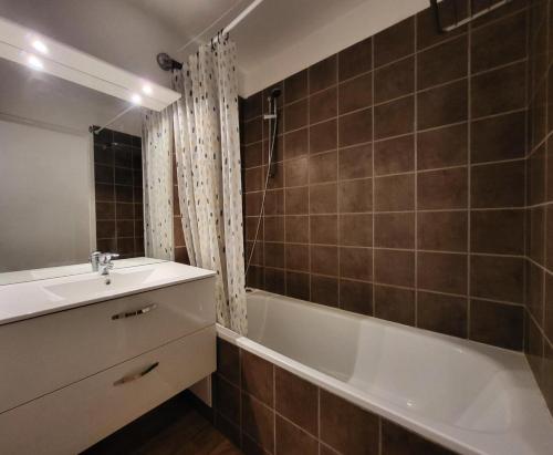 une salle de bain avec un lavabo et une baignoire dans l'établissement Les Chalets De Bois MÉan - A - Duplex 6 couchages joliment décoré MAE-3731, aux Orres