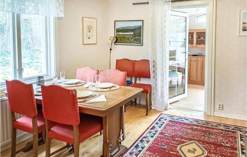 a dining room with a table and red chairs at Gorgeous Home In Markaryd in Hässlehult