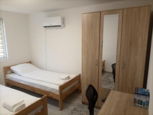 een kleine kamer met twee bedden en een spiegel bij Villa NEA Ilidza in Sarajevo