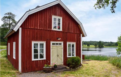 a red barn next to a body of water at 2 Bedroom Gorgeous Home In Bottnaryd in Bottnaryd