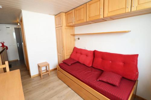 - un canapé avec des oreillers rouges dans l'établissement Résidence Palafour - Studette rénovée MAE-5531, à Tignes