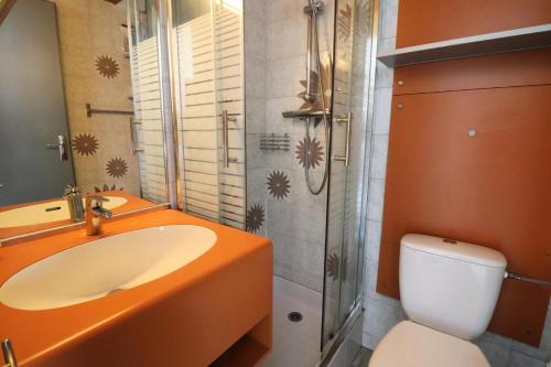 La salle de bains est pourvue d'un lavabo orange et de toilettes. dans l'établissement Résidence Palafour - Studio lumineux · Pieds des pistes · Proche commerces MAE-5541, à Tignes