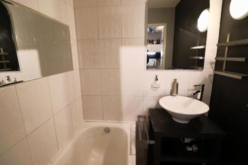 une salle de bain avec une baignoire blanche et un lavabo dans l'établissement Résidence Hameau Du Borsat 3 - Appartement ski aux pieds·Balcon·Parking MAE-9681, à Tignes