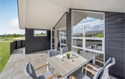 a dining room with a table and chairs on a patio at 3 Bedroom Amazing Home In Tarm in Tarm