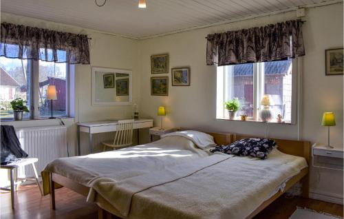 a bedroom with a bed and two windows at Awesome Home In Vittsjö in Vittsjö