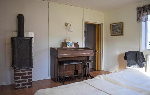 a living room with a piano and a bed at Awesome Home In Vittsjö in Vittsjö