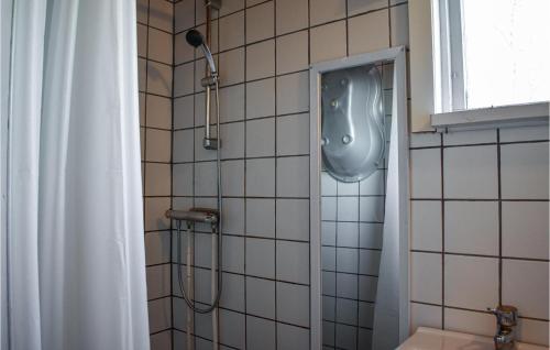 a bathroom with a shower with a urinal on the wall at Awesome Home In Vittsjö in Vittsjö
