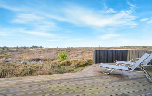 a white chair sitting on a wooden deck at Holiday Home Godthåbsvej Rømø Vi in Bolilmark
