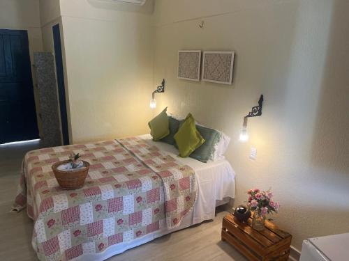 a bedroom with a bed with green pillows at Pousada Vila do Mar in São Luís