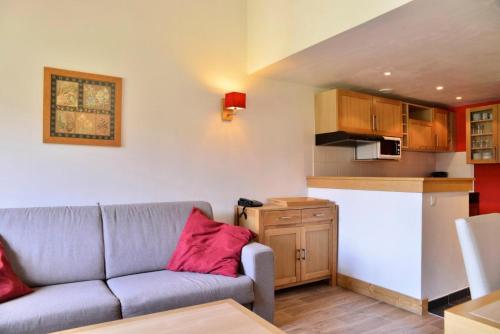 un salon avec un canapé et une cuisine dans l'établissement Résidence Le Centaure - 2 Pièces pour 6 Personnes 531, à Aime La Plagne