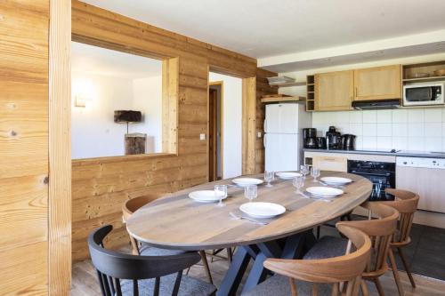 une cuisine avec une table et des chaises en bois dans l'établissement Résidence Le Centaure - 5 Pièces pour 10 Personnes 551, à Aime La Plagne