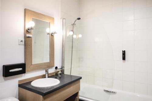 une salle de bain avec un lavabo, un miroir et une baignoire dans l'établissement Résidence Le Centaure - 5 Pièces pour 10 Personnes 551, à Aime La Plagne