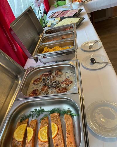 a buffet with several trays of food on a table at Landgasthaus Sankt Annen in Sankt Annen