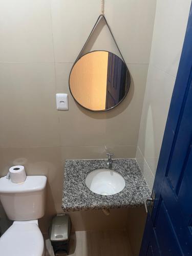 a bathroom with a sink and a mirror and a toilet at Pousada Vila do Mar in São Luís