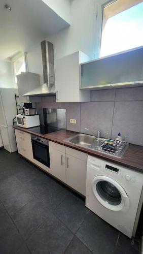une cuisine avec une machine à laver et un évier dans l'établissement T3 moderne hyper centre parking privé, à Toulouse