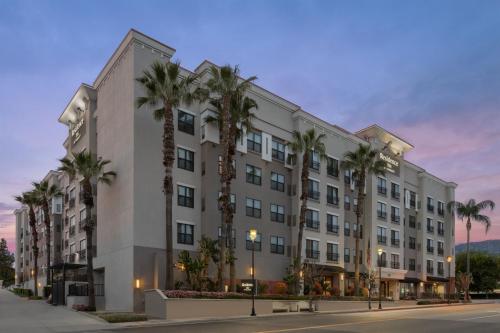 a building with palm trees in front of a street at Residence Inn Los Angeles Burbank/Downtown in Burbank