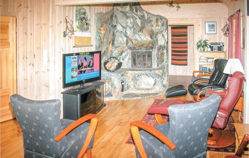 sala de estar con sillas, TV y pared de piedra en Stunning Home In Sogndal With Sauna, en Svidalen