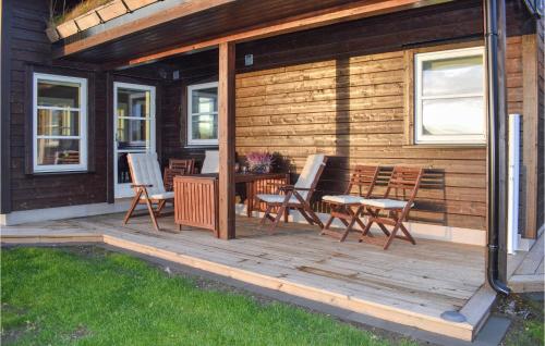 a wooden deck with chairs and a table on a house at Lovely Home In Hjartdal With Sauna in Hjartdal