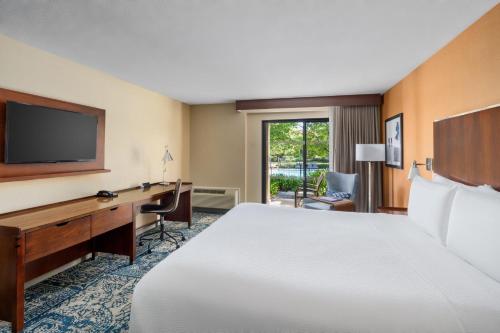 a hotel room with a bed and a desk and a television at Four Points by Sheraton Pleasanton in Pleasanton