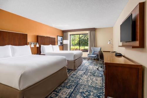 a hotel room with two beds and a flat screen tv at Four Points by Sheraton Pleasanton in Pleasanton