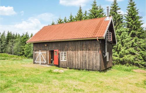 an old barn with a red door in a field at 3 Bedroom Awesome Home In Årjäng in Årjäng