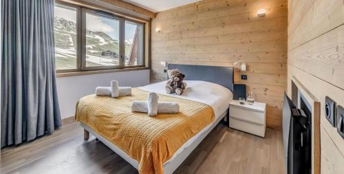 une chambre avec un lit avec un ours en peluche dessus dans l'établissement Résidence Phoenix - 5 pièces 8 personnes PREMIUM 4 MAE-2021, à Tignes