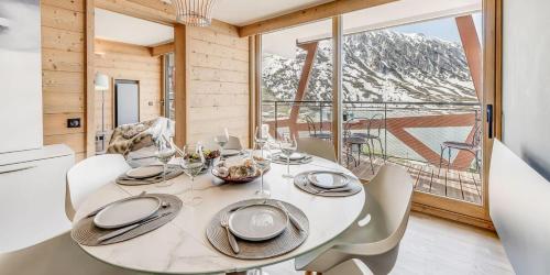 une salle à manger avec une table et des chaises et une grande fenêtre dans l'établissement Résidence Phoenix - 5 pièces 8 personnes PREMIUM 4 MAE-2021, à Tignes