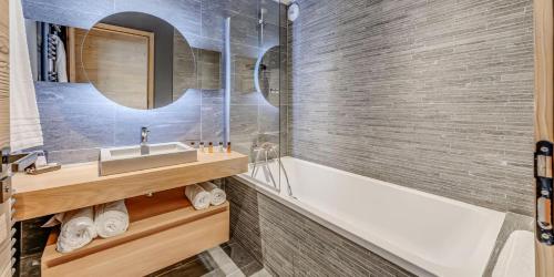 une salle de bain avec un lavabo et une baignoire dans l'établissement Résidence Phoenix - 5 pièces 8 personnes PREMIUM 4 MAE-2031, à Tignes