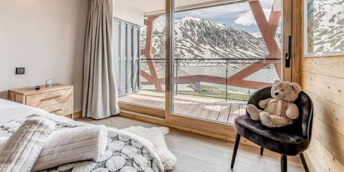 un ours en peluche assis sur une chaise dans une chambre dans l'établissement Résidence Phoenix - 5 pièces 8 personnes PREMIUM 4 MAE-2031, à Tignes