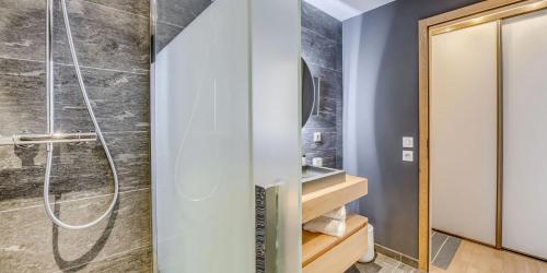 une douche avec une porte vitrée dans une salle de bain dans l'établissement Résidence Phoenix - 3 pièces cabine 6 personnes 4 MAE-2041, à Tignes