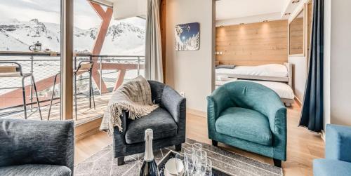 une chambre avec deux chaises, un lit et un balcon dans l'établissement Résidence Phoenix - 3 pièces cabine 6 personnes 4 MAE-2041, à Tignes