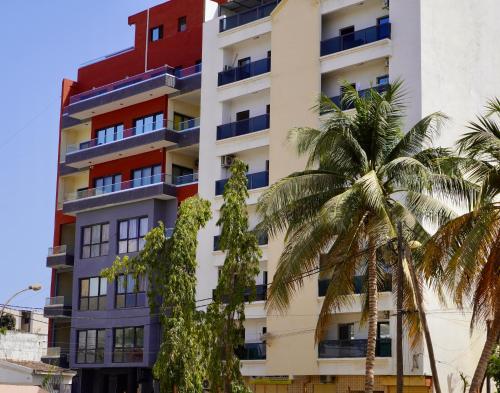 a building with palm trees in front of it at F2 tout confort au Point E Dakar ! in Dakar