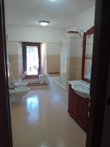 La salle de bains est pourvue de 2 lavabos et de 2 toilettes. dans l'établissement La casa di Bobo, à Pian degli Ontani
