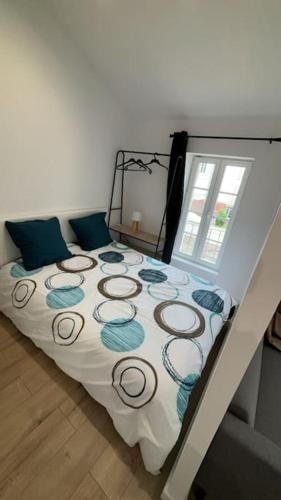 une chambre avec un grand lit avec des oreillers bleus dans l'établissement Studio tout confort avec climatisation, à Agen