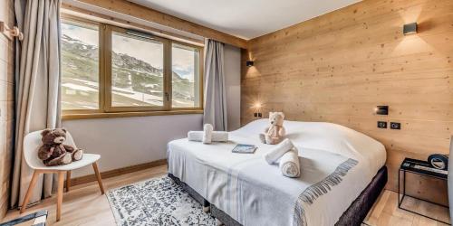 - une chambre avec deux ours en peluche assis sur un lit dans l'établissement Résidence Phoenix - 5 Pièces pour 9 Personnes MAE-7991, à Tignes