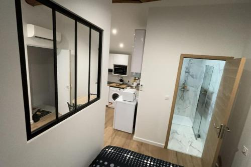 une petite cuisine blanche avec un miroir et un évier dans l'établissement Studio tout confort avec climatisation, à Agen