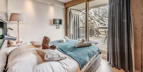 une chambre avec un grand lit et un balcon dans l'établissement Résidence Phoenix - 2 pièces cabine 5 personnes 4 MAE-8001, à Tignes