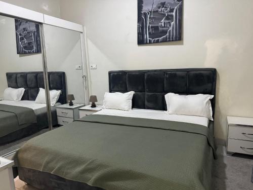 a bedroom with a large bed and a large mirror at F2 tout confort au Point E Dakar ! in Dakar