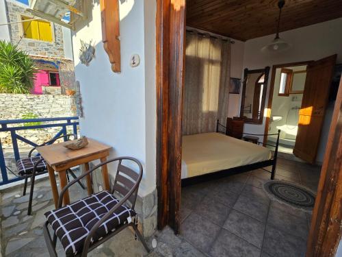 a room with a bed and a table and a chair at Aglaia studios fournoi in Fourni Ikarias