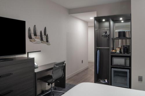 a bedroom with a desk with a tv and a refrigerator at Fairfield by Marriott Inn & Suites Annapolis in Annapolis