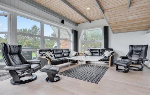 a living room with leather chairs and a table at Beautiful Home In Rømø With Sauna in Rømø Kirkeby
