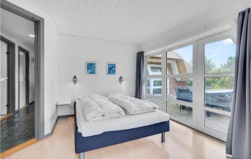 a bedroom with a bed and a large window at Beautiful Home In Rømø With Sauna in Rømø Kirkeby