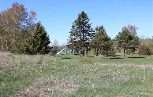 a field with trees and a building in the distance at Gorgeous Home In Löttorp With Wifi in Löttorp
